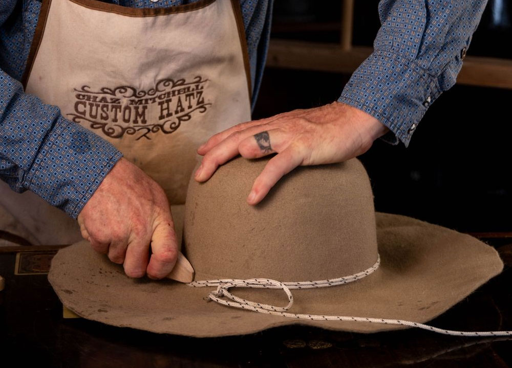 A man working on a hat.